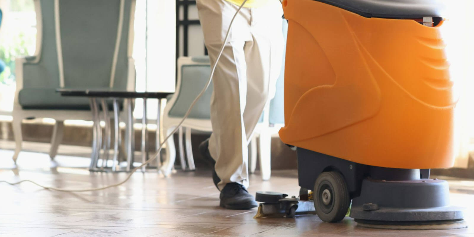 man is cleaning the floor using a large electric mop