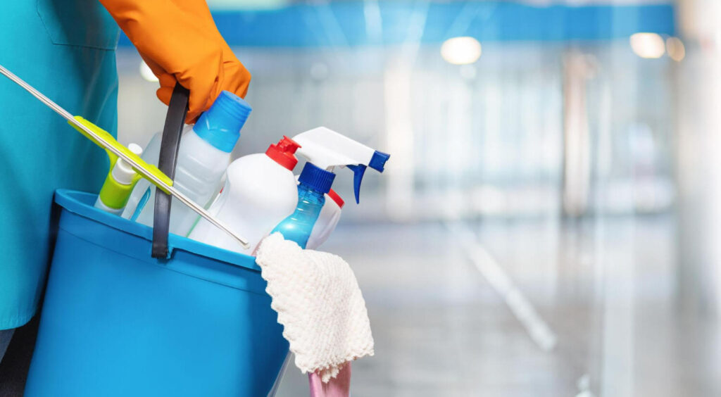 professional cleaner holding a bucket of cleaning tools