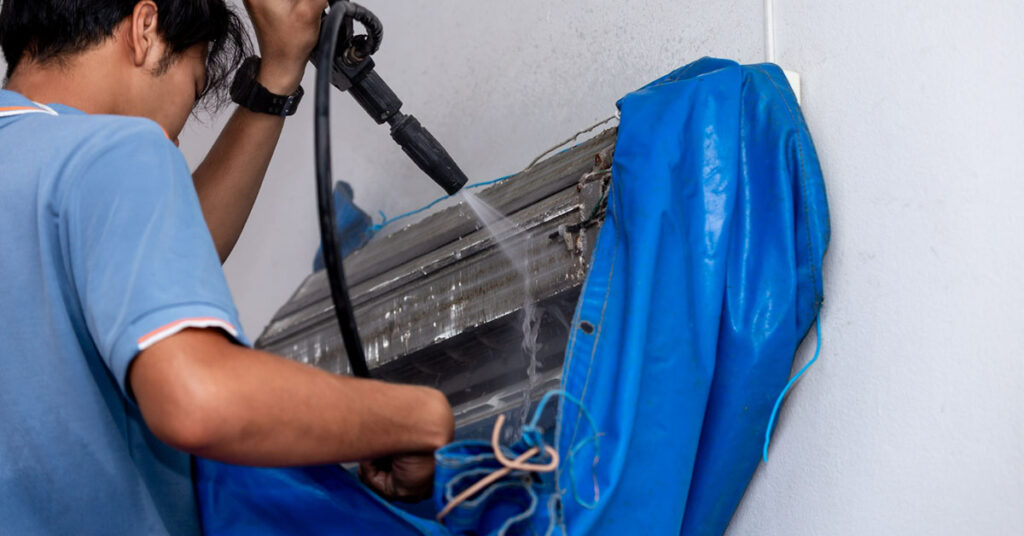 air conditioner cleaner is spraying water into the air conditioner