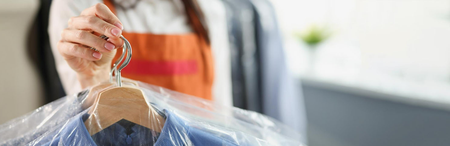 laundry worker is holding clothes on a hanger
